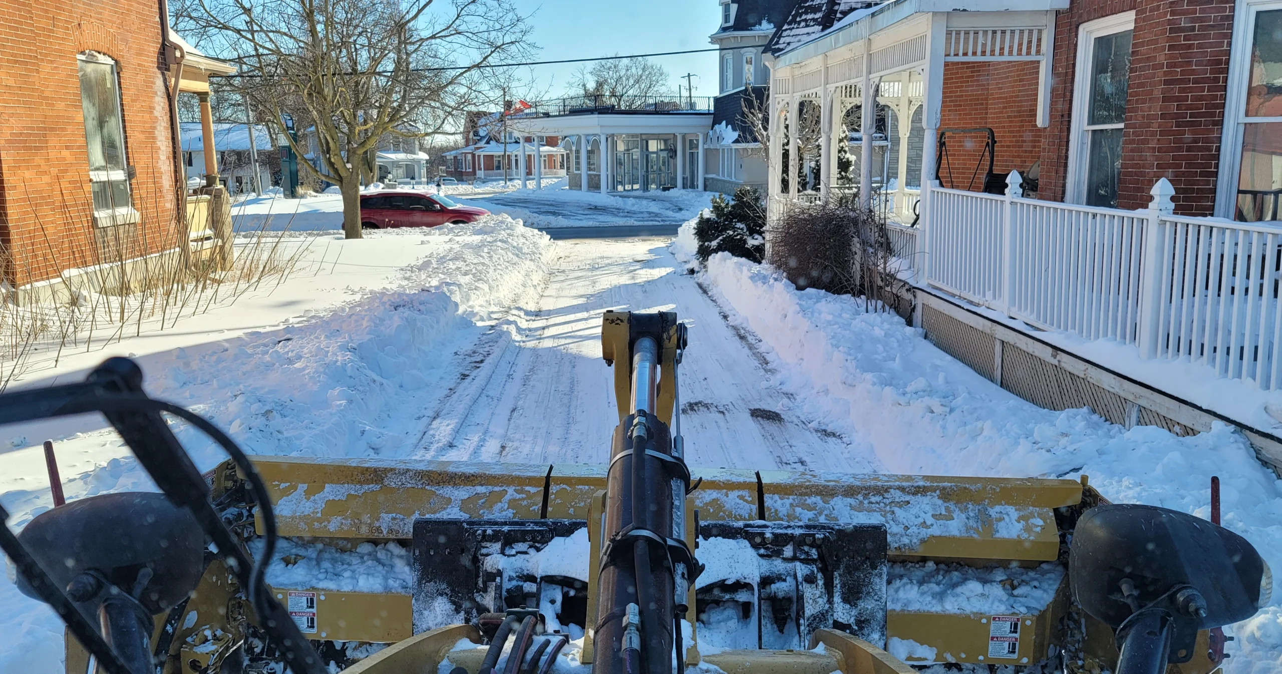 Plow truck clearing a snow-covered residential street