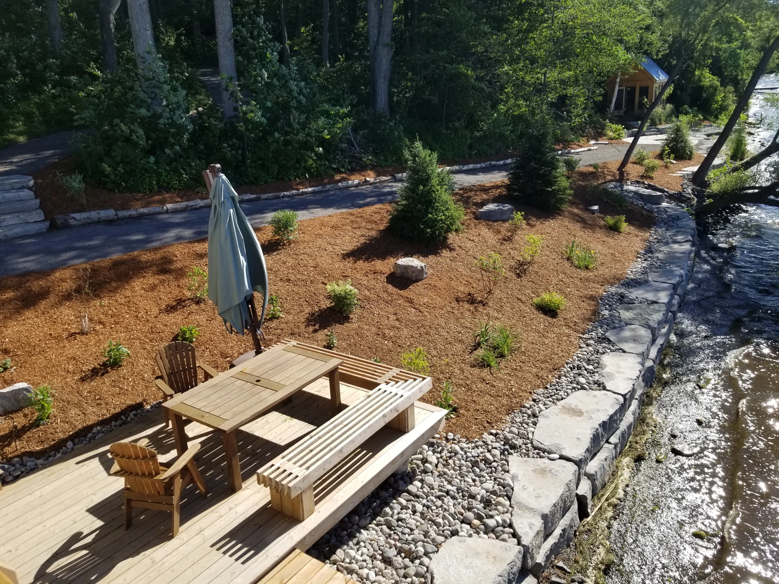 Planted bed and patio with a garden umbrella