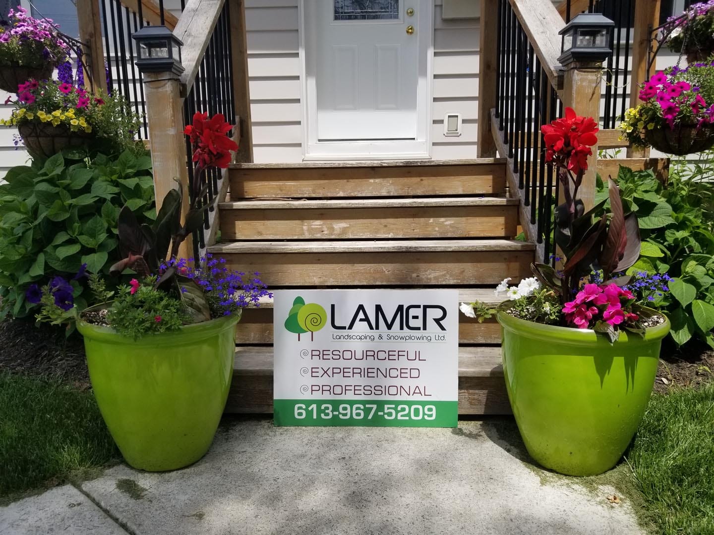 Lamer seasonal planters with flowers at a front entrance