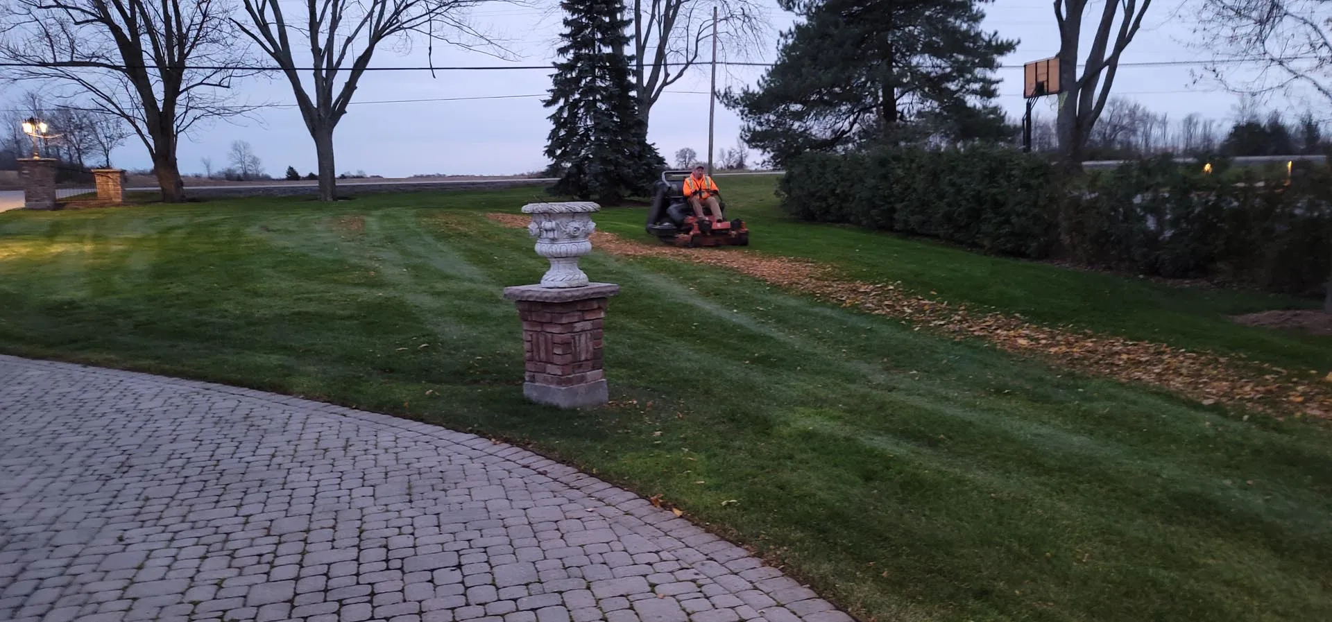 Lamer crew giving a large estate lawn its final fall mow and leaf cleanup