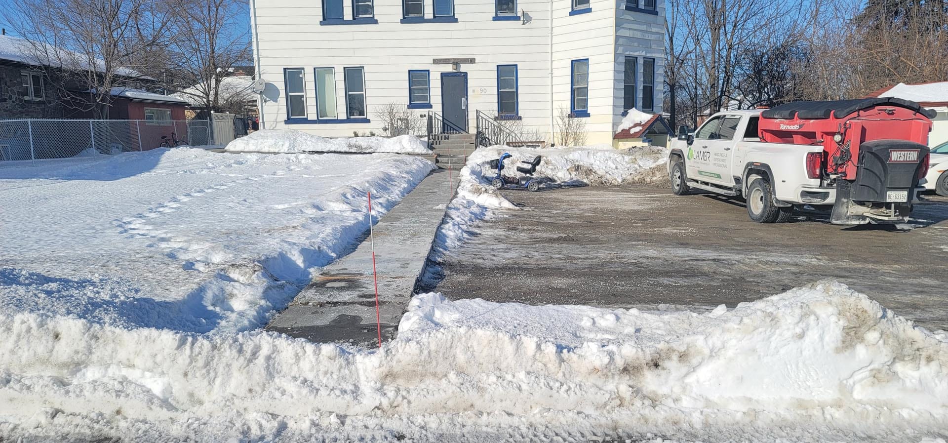 Lamer crew clearing snow on a commercial lot