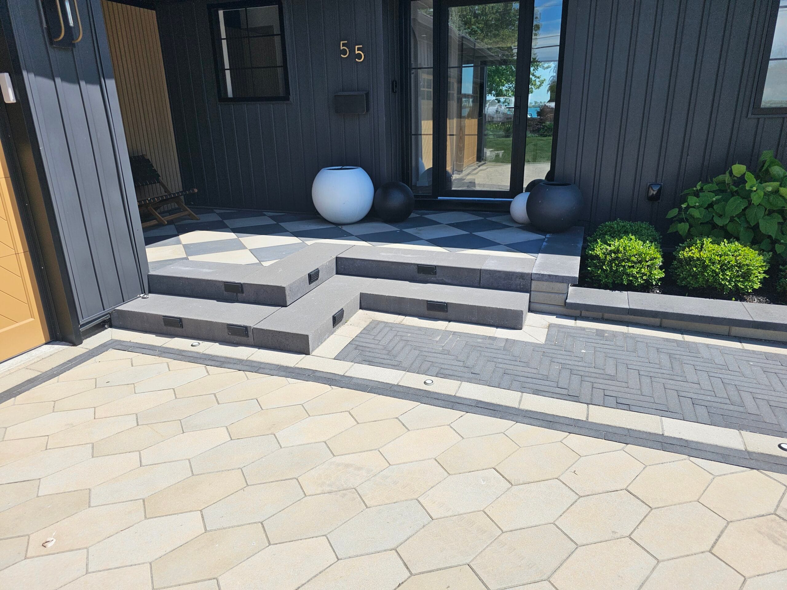 Modern concrete block retaining wall and steps with planted beds